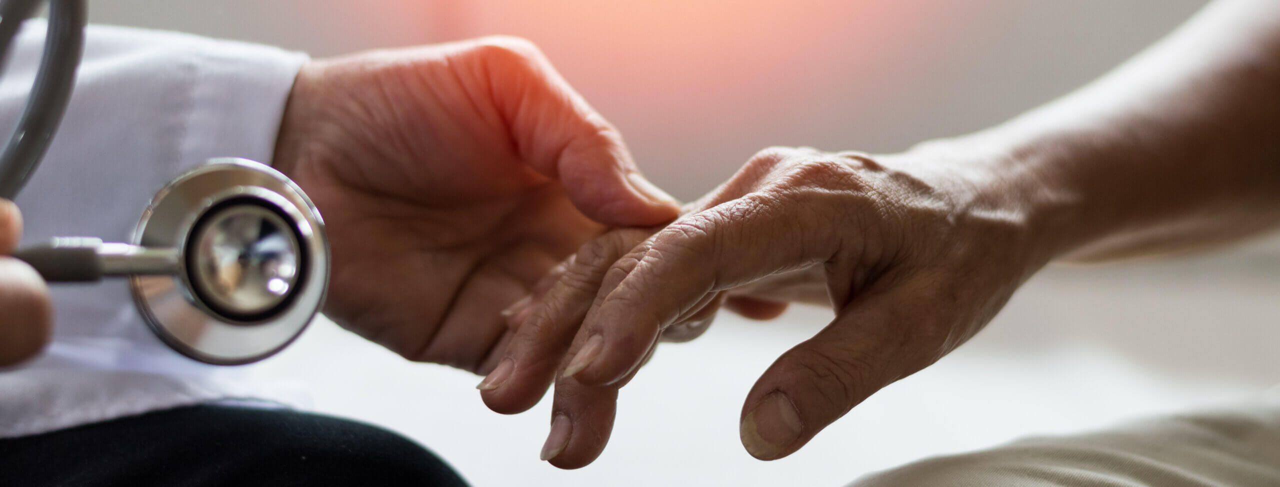Doctor holding hand of patient with Parkinson's.